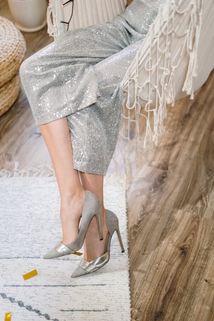 Stylish woman in sequined pants and heels relaxing in a hammock indoors.